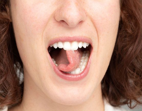 Frau dreht Zunge logopädische Übung